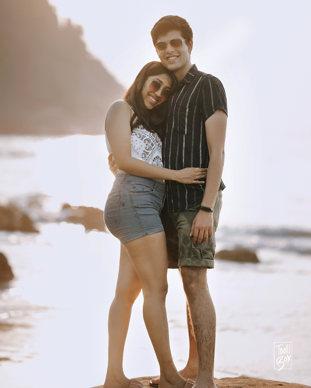 Dipti and Akash embracing on the beach in the evening light