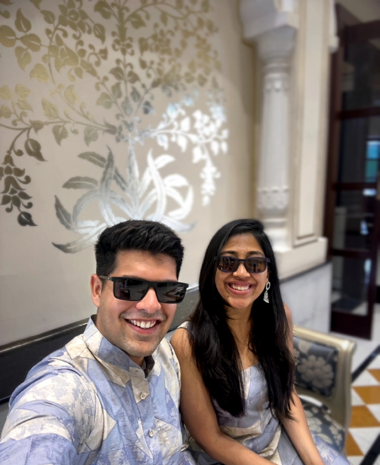 Dipti and Akash in matching pale blue Indian outfits and sunglasses