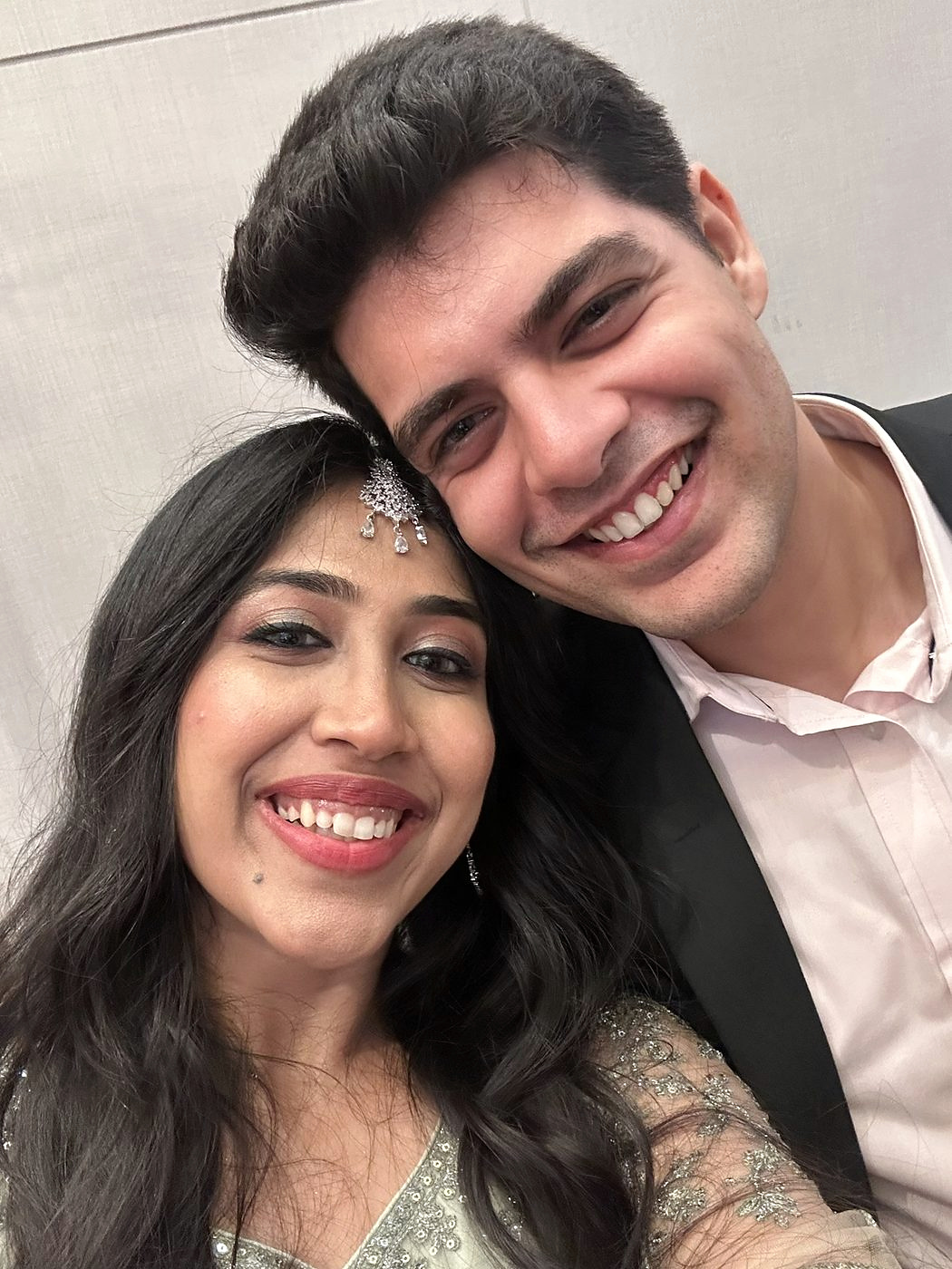 Dipti dressed for a function with Akash in a white shirt, both laughing