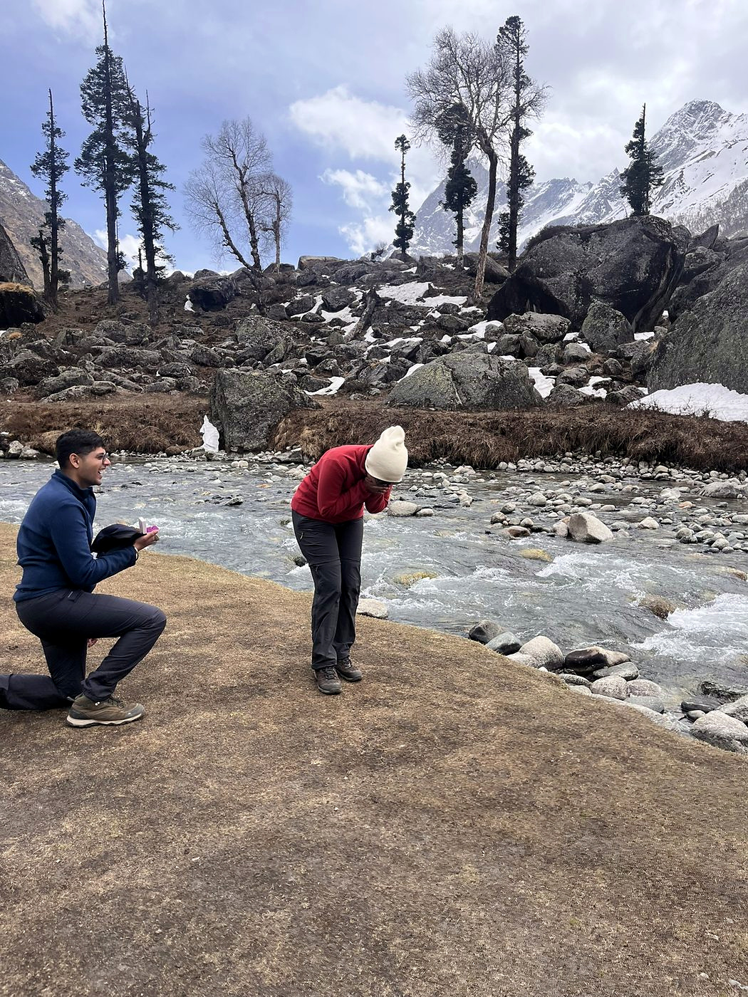 The proposal. Akash on one knee beside a river in the Har Ki Dun valley